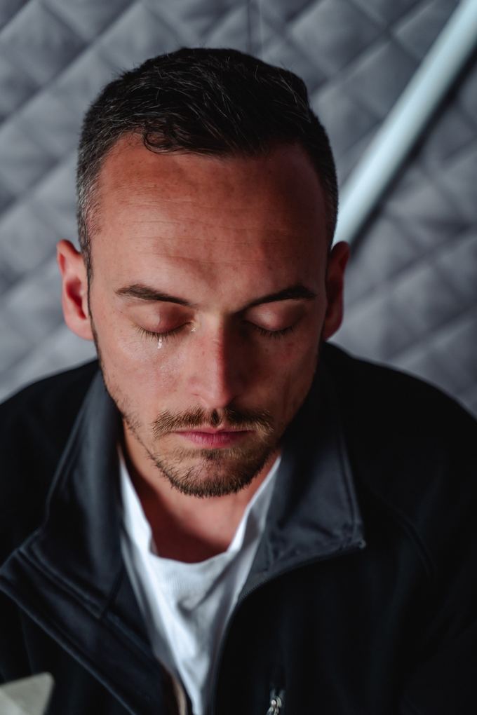 Close portrait of Tyler with his eyes closed, listening